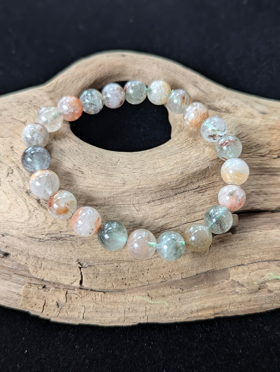 10mm Light Garden Quartz (Lodolite) Bracelet, showing striking clear beads with earthy inclusions on driftwood.