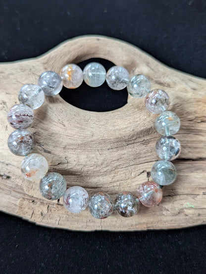 12mm Light Garden Quartz (Lodolite) Bracelet, showing bold, chunky beads with earthy inclusions on driftwood.