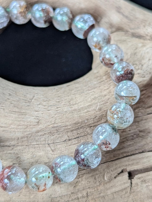 Close-up of 8mm Light Garden Quartz (Lodolite) Bracelet, showing suspended chlorite and iron oxide within clear quartz.