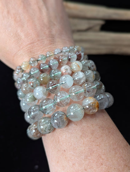 Multiple Light Garden Quartz (Lodolite) Bracelets of varying sizes stacked together on a wrist.