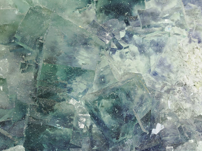 Macro close-up showing the stepped, intergrown crystal habit and watery translucence of the fluorite.