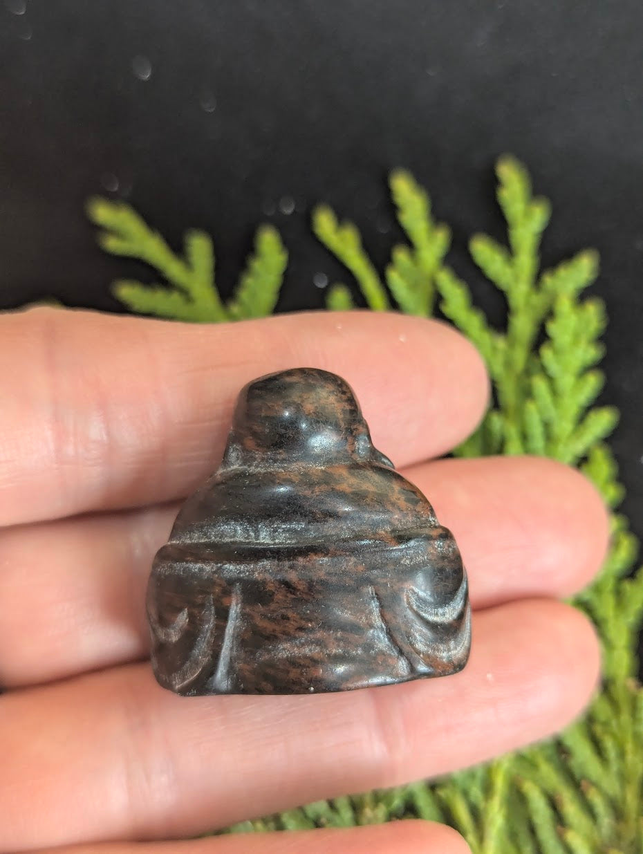 he rear view of a Mahogany Obsidian Buddha totem showing the flow of the reddish-brown hematite patterns within the volcanic glass.