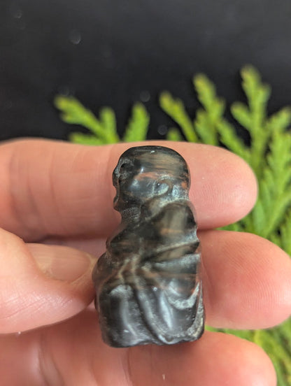 Side profile view of a Mahogany Obsidian Buddha carving illustrating the depth and rounded contours of the 1.8cm thick stone.
