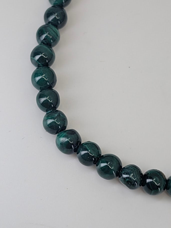 Close-up of Malachite bead pattern showing natural swirling green bands