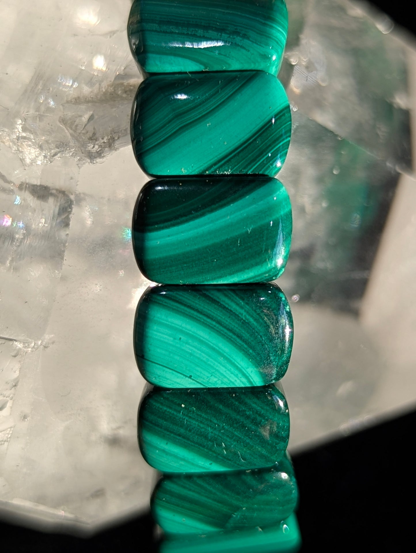 Macro detail of rectangular-cut malachite beads highlighting vibrant natural green banding and vitreous luster.