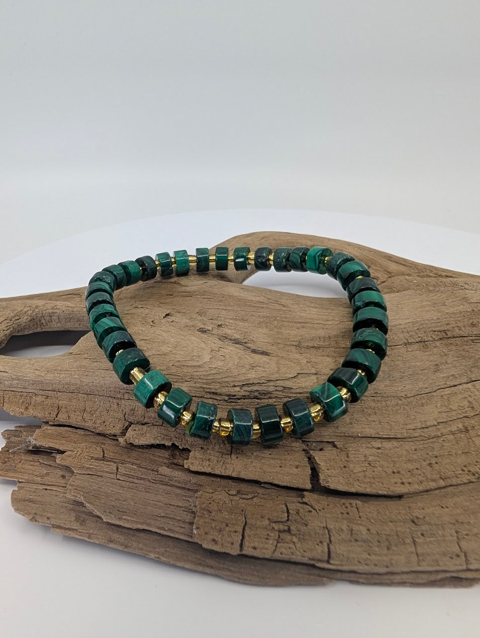 Natural malachite cube bracelet on driftwood showing deep green banding