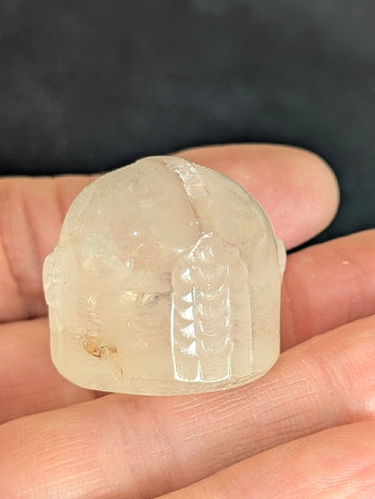 Rear view of a hand-held Clear Quartz Mandalorian helmet carving.