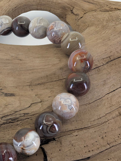 Close-up of 8mm Crazy Lace Agate beads highlighting the "festooned" lace-like patterns and earthy colors.