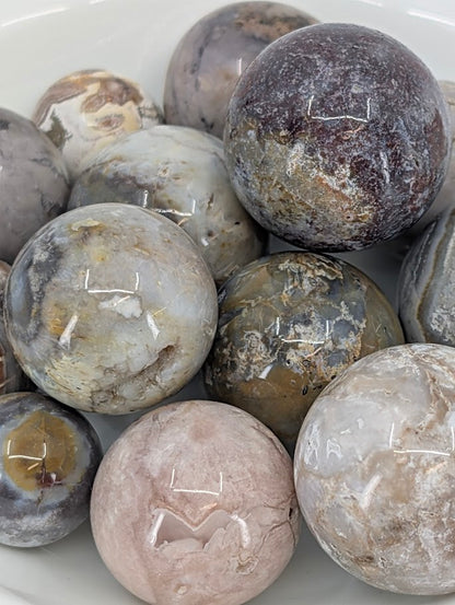 Close-up of Mexican Lace Agate mini spheres with intricate bands and warm tones
