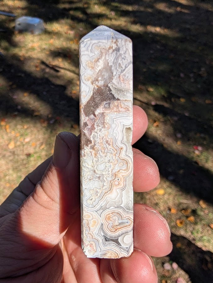 Mexican Lace Agate Tower #4 angled view — polished agate with multiple quartz-lined vugs