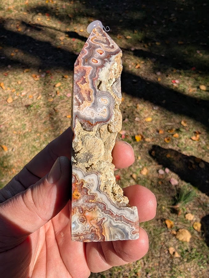 Mexican Lace Agate Tower #6 side view — polished banding contrasted with raw vug and matrix