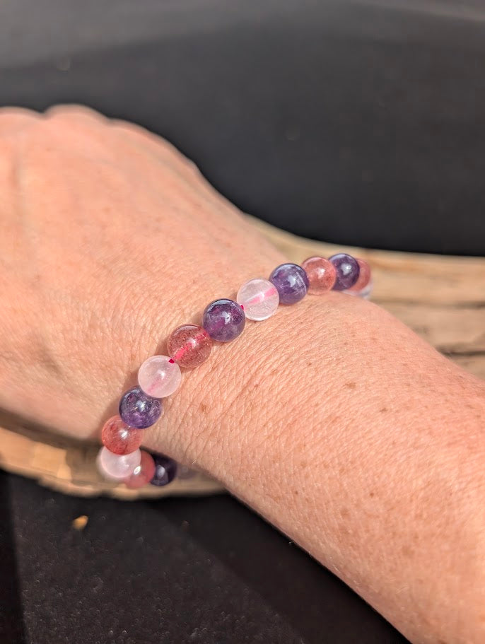 Natural sunlight on an 8mm purple and pink mixed quartz stretch bracelet worn on a wrist.