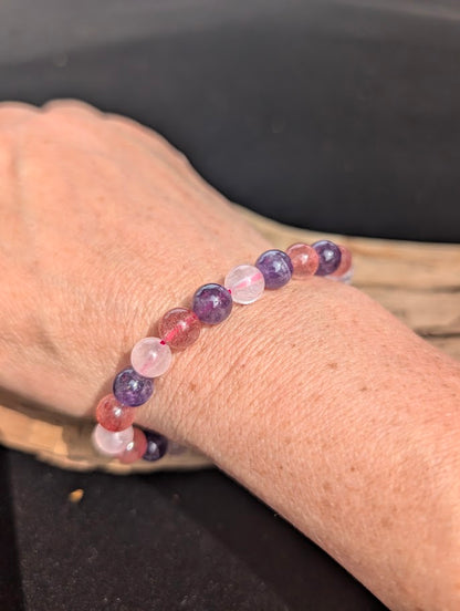 Natural sunlight on an 8mm purple and pink mixed quartz stretch bracelet worn on a wrist.