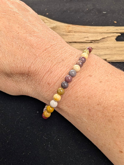 4mm polished Mookaite beaded stretch bracelet worn on a wrist for delicate size scale.