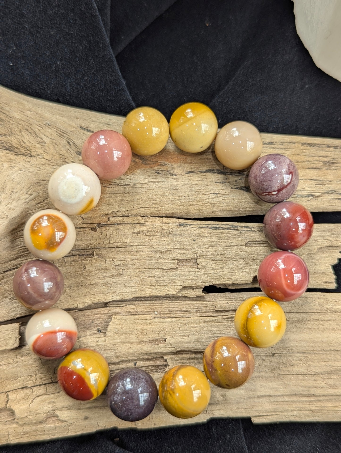 An oversized 12mm Mookaite bead statement bracelet from Western Australia perfectly balanced on a piece of natural driftwood.