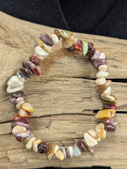 An all-natural Mookaite chip stretch bracelet from Western Australia beautifully displayed on natural driftwood.