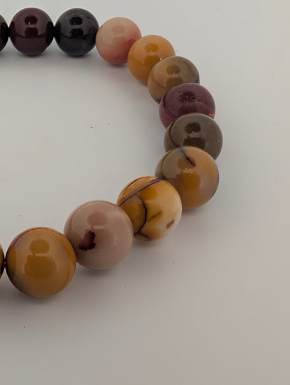 Close-up of 8MM Mookaite beads with ochre and burgundy tones