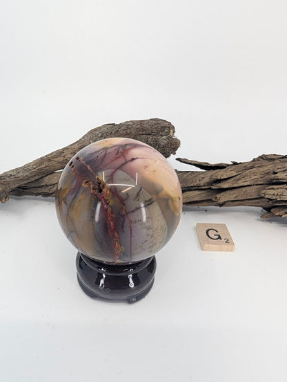 Side view of Mookaite sphere G showing natural landscape-like scenery.