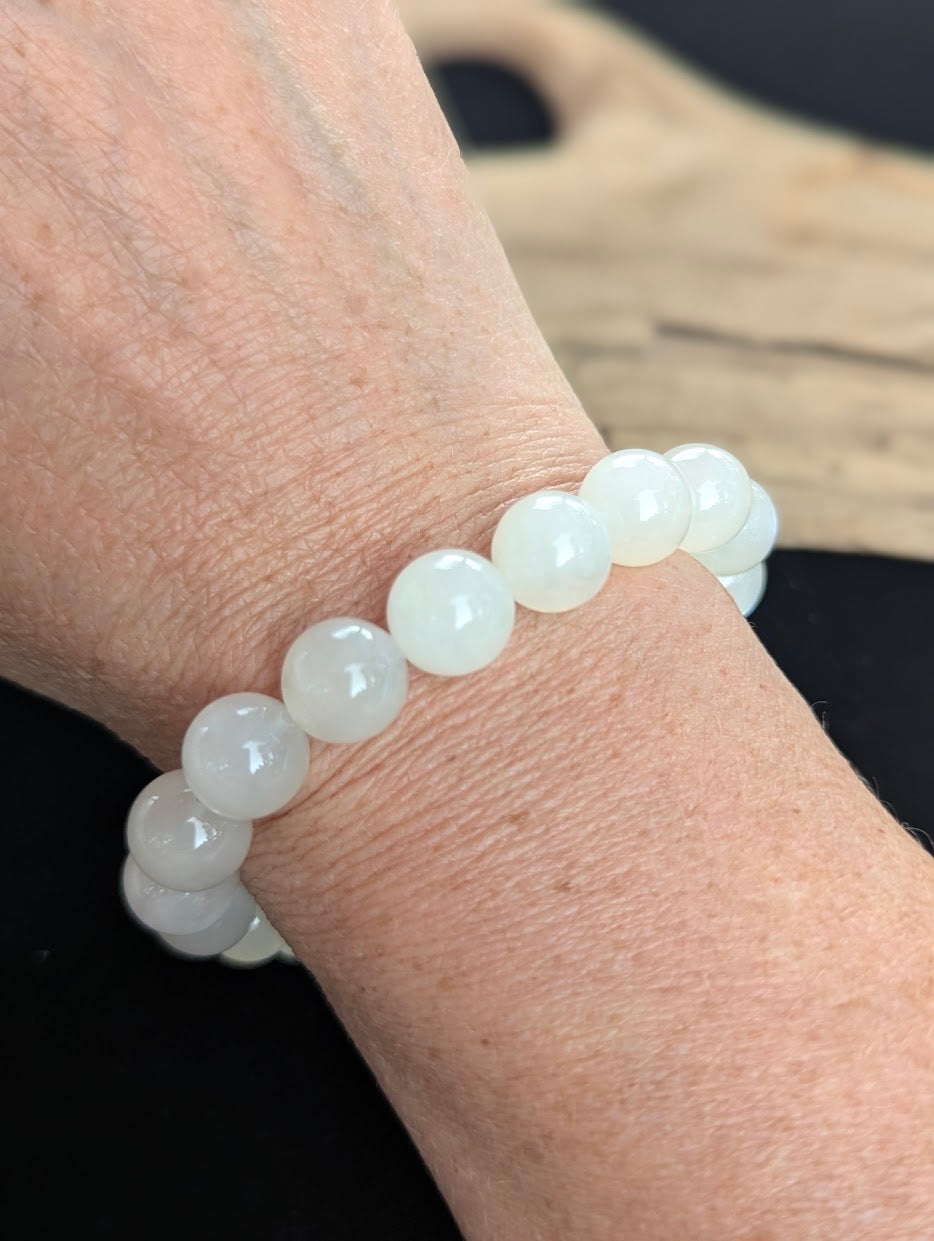 11mm cloudy white Sri Lankan Moonstone bracelet being worn on a wrist.