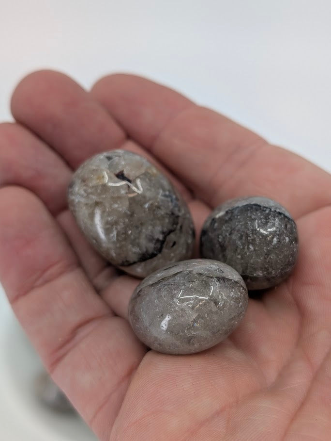 Mosaic Jasper tumbled stones shown in hand for scale