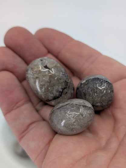 Mosaic Jasper tumbled stones shown in hand for scale