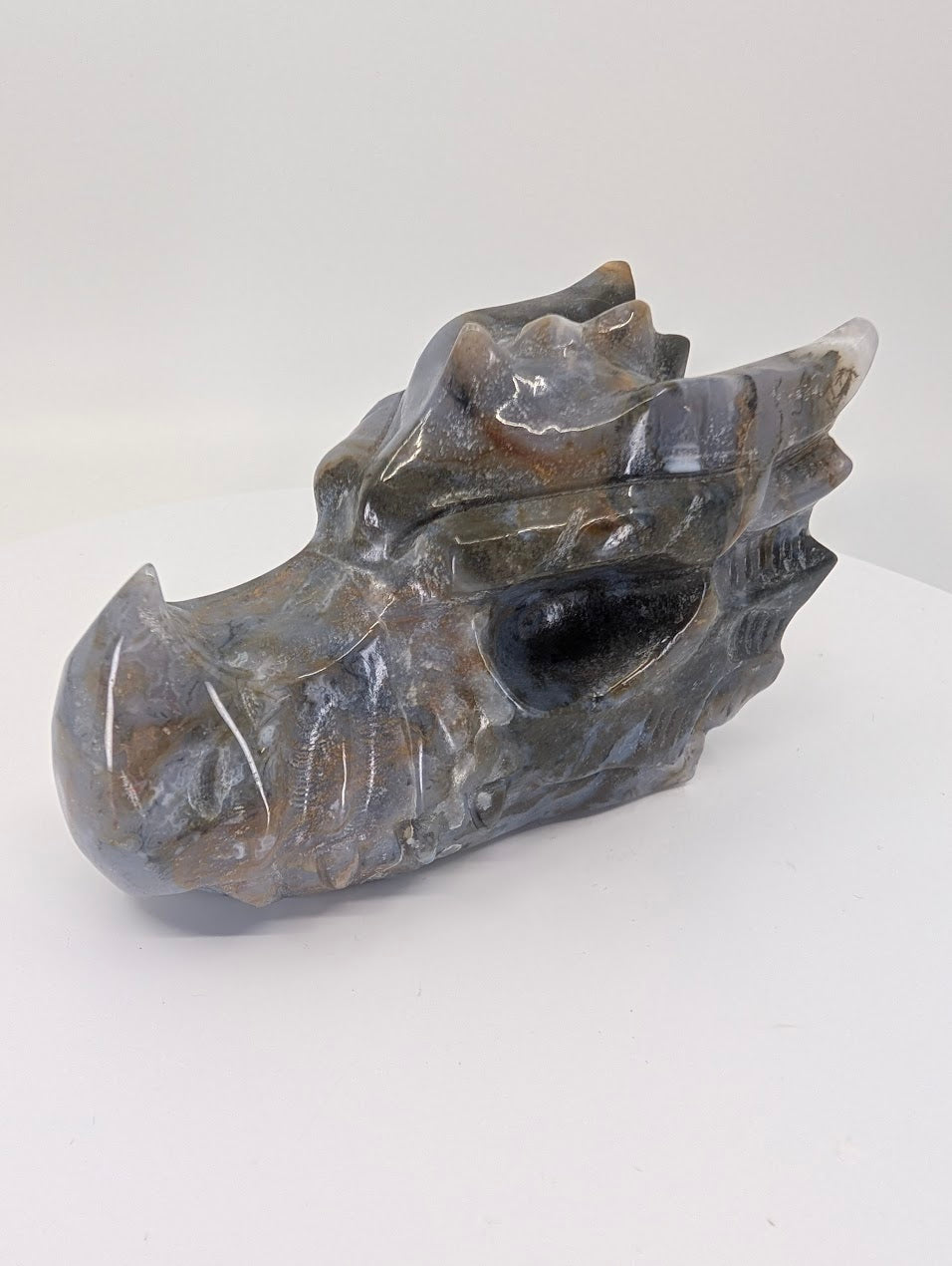 Side view of moss agate dragon head showing smoky chalcedony and moss patterns