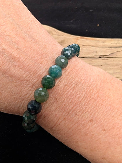 8mm faceted Moss Agate beaded stretch bracelet worn on a wrist for size scale.