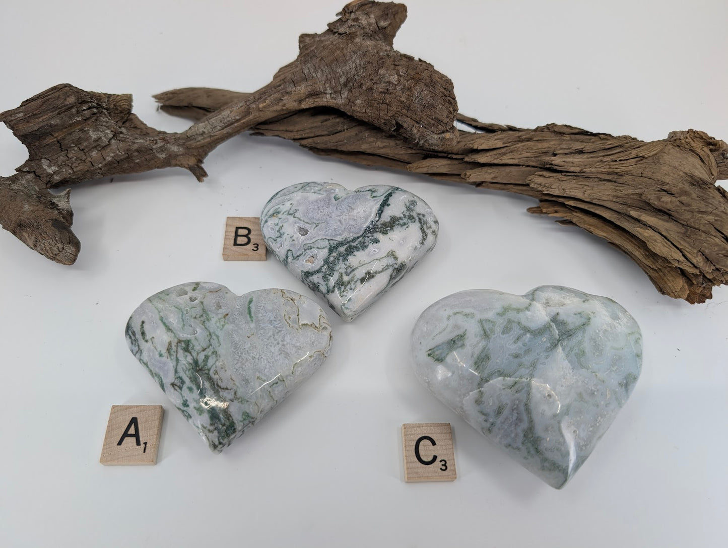Back side of group of three Moss Agate hearts labeled A, B, and C showing sparkling geode pockets.