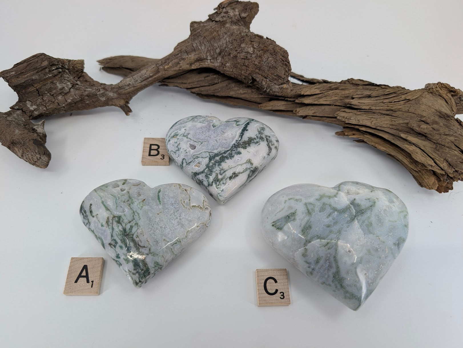Back side of group of three Moss Agate hearts labeled A, B, and C showing sparkling geode pockets.
