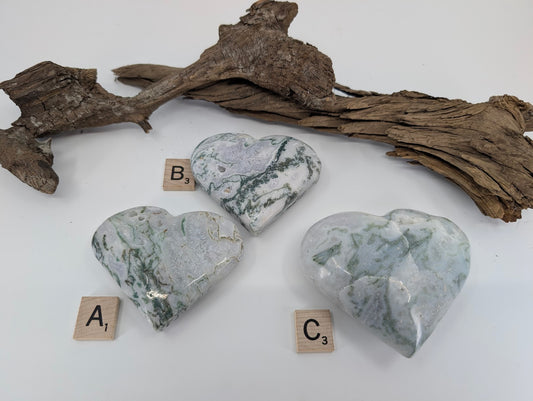 Back side of group of three Moss Agate hearts labeled A, B, and C showing sparkling geode pockets.