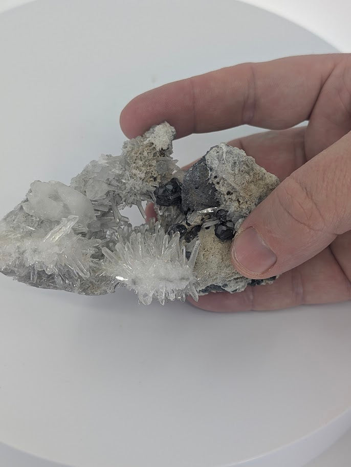 Natural formation of blocky black pyrite crystals clustered on a quartz matrix.