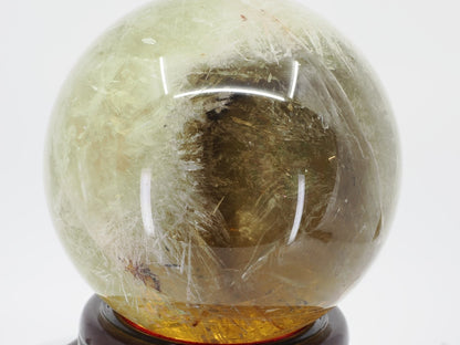 Side view of citrine sphere contrasting a clear honey quartz window against dense white goethite sprays.
