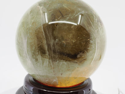 Large natural citrine sphere showing complex internal geological planes and smoky golden depth.