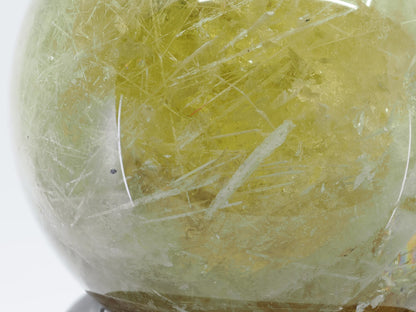 Macro detail of yellow natural citrine quartz with fine acicular crystal inclusions.