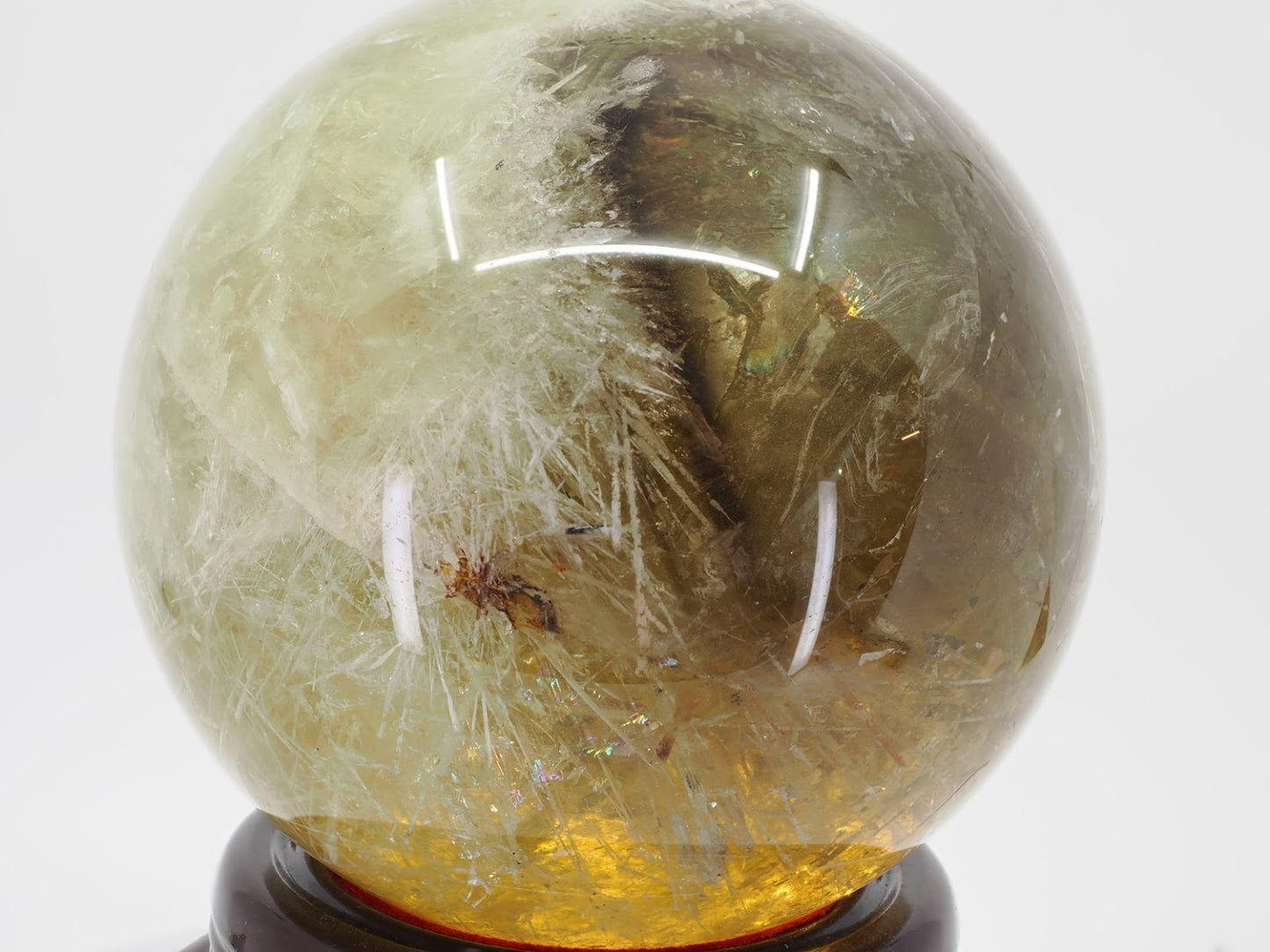 Natural Citrine sphere displaying large internal phantom structures and a dense patch of white snowflake inclusions.