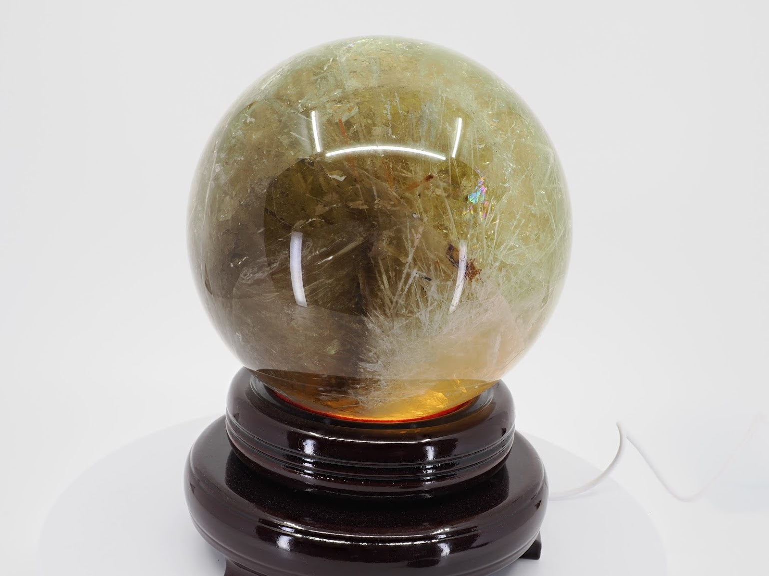 Natural Citrine sphere showing distinct white snowflake goethite inclusions and deep amber tones.