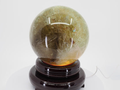 Natural Citrine sphere showing distinct white snowflake goethite inclusions and deep amber tones.