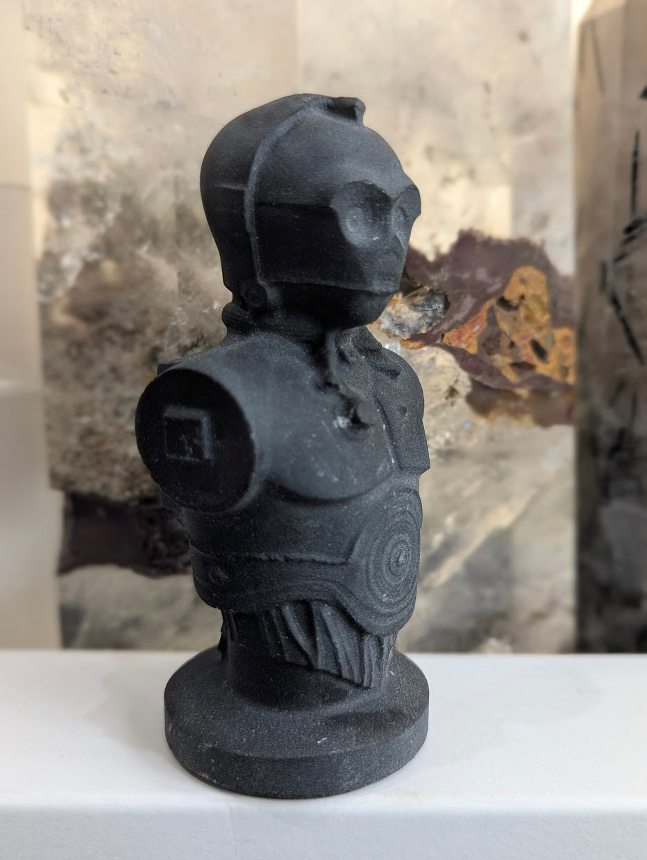 Angled view of matte volcanic glass C-3PO showing mechanical details.