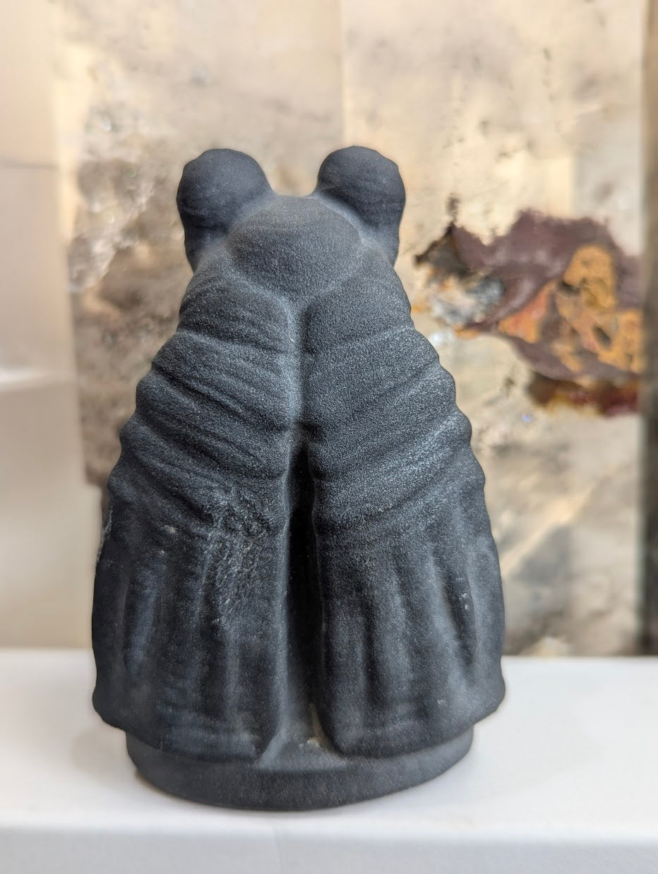 Back view of matte black volcanic glass Jar Jar Binks carving.