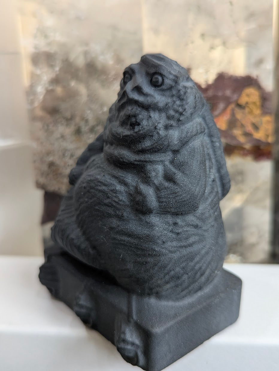 Profile view of hand-carved obsidian Jabba the Hutt.