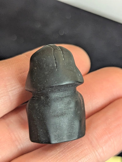 Reverse view of a matte black obsidian Darth Vader carving showing the smooth matte finish and helmet structure.