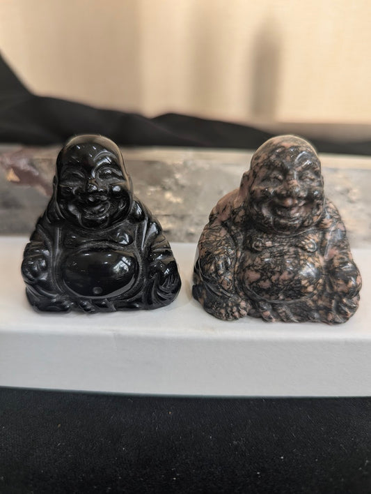 Group photo showing two hand-carved Laughing Buddha figurines in Black Obsidian and Rhodonite for size and color comparison.