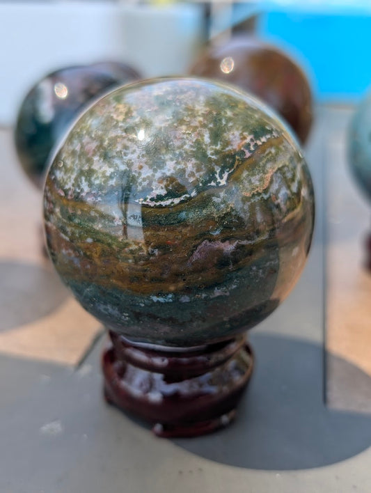 AA-grade 63mm Ocean Jasper sphere from Madagascar showing OJS-01 weight label.