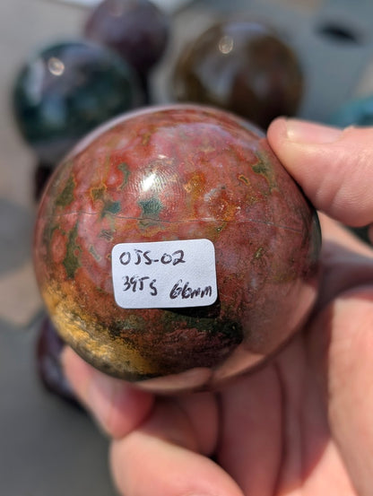 AA-grade 66mm Ocean Jasper sphere from Madagascar showing OJS-02 weight label.