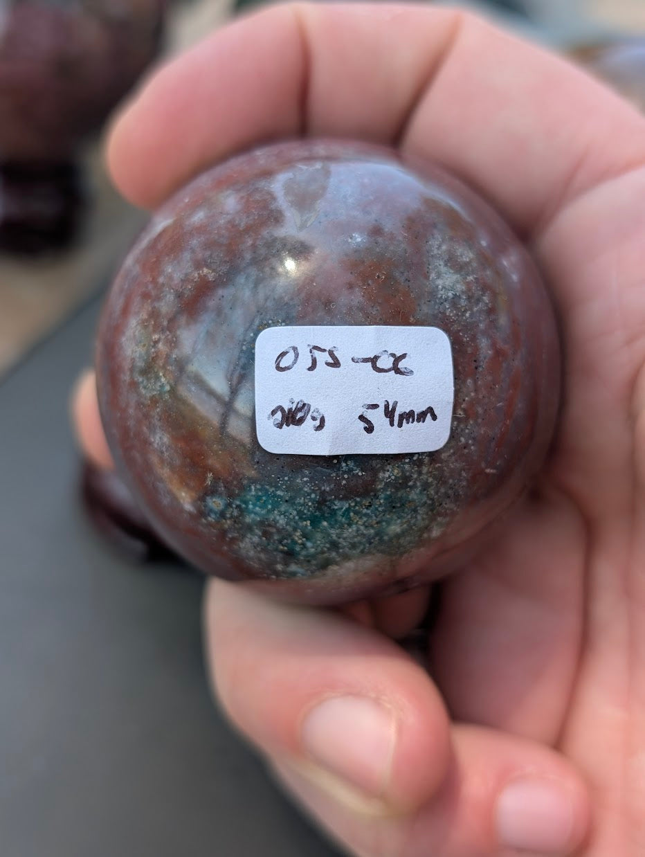 AA-grade 54mm Ocean Jasper sphere from Madagascar showing OJS-06 weight label.