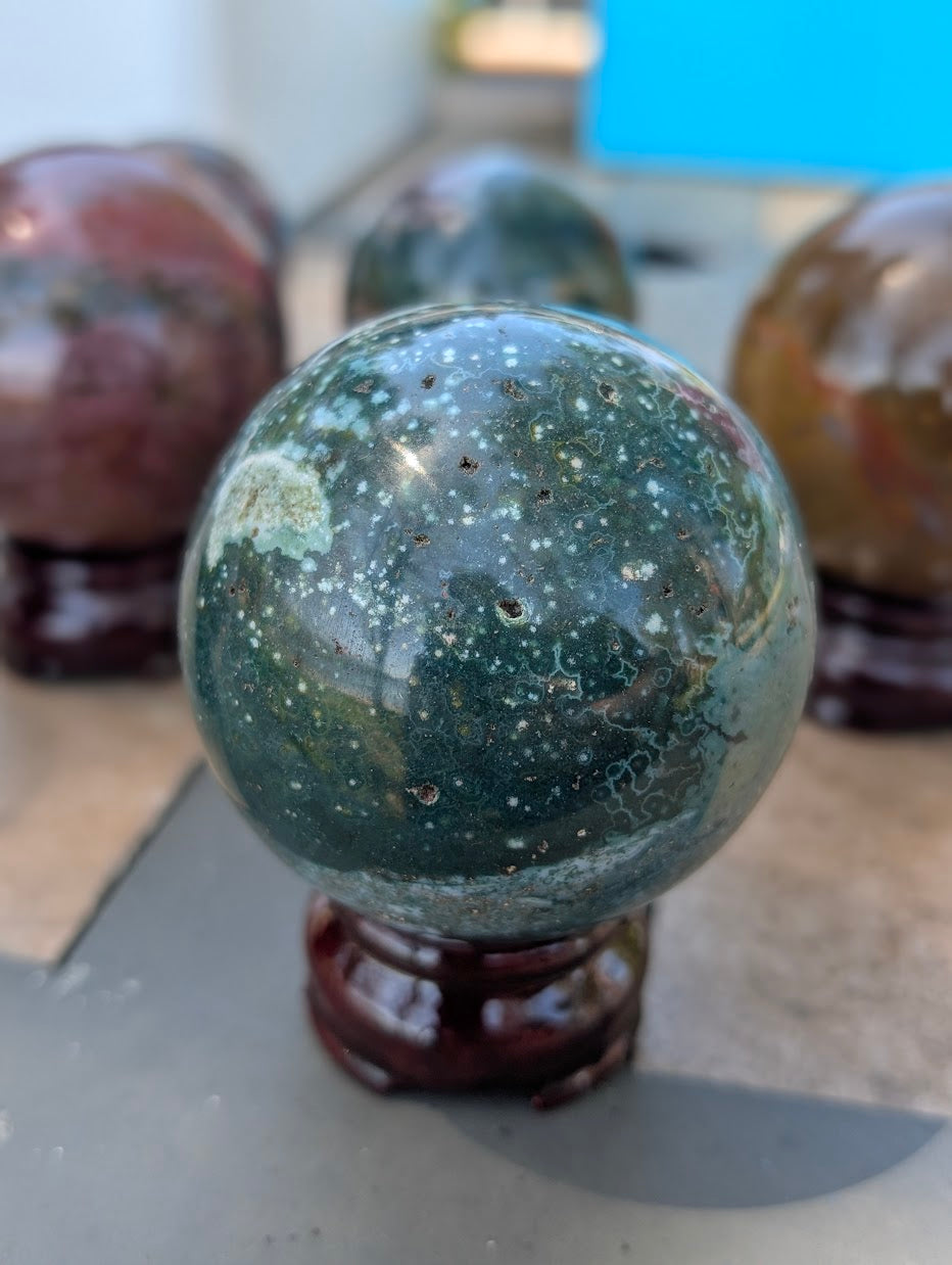 66mm Ocean Jasper sphere displaying a harmonious blend of green, red, and white.