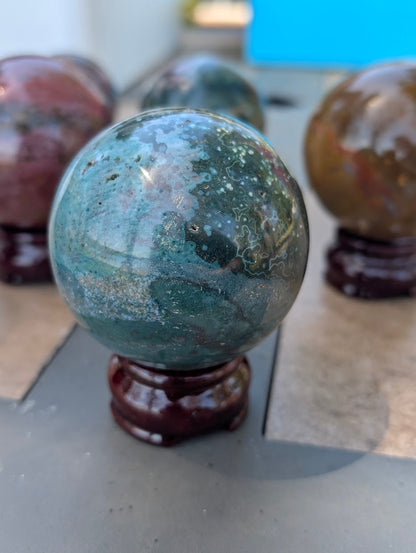 High-gloss polished surface of 66mm Ocean Jasper sphere from Madagascar.