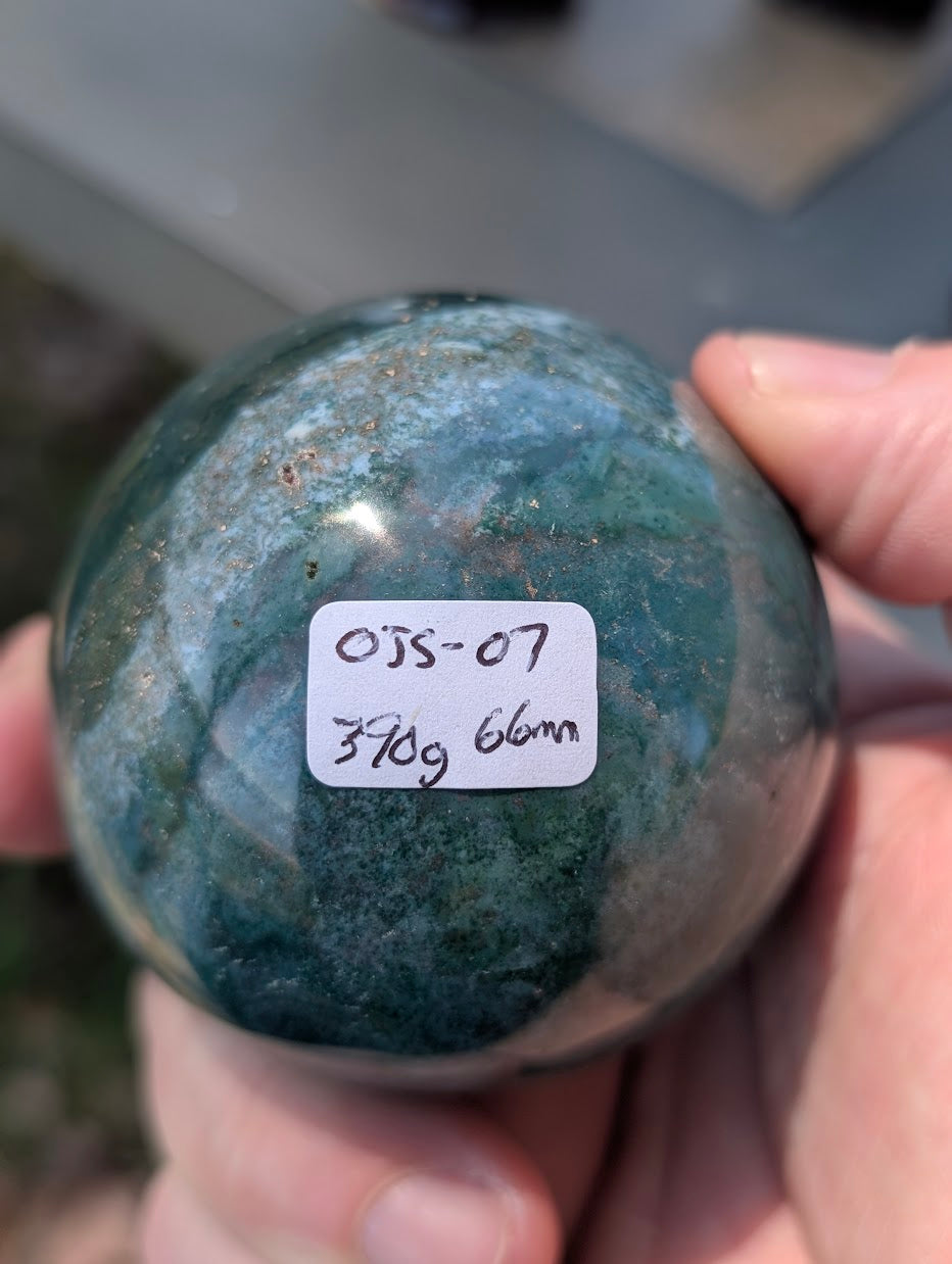 AA-grade 66mm Ocean Jasper sphere from Madagascar showing OJS-07 weight label.
