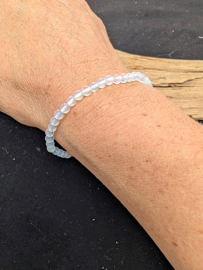 4mm polished Opalite beaded stretch bracelet worn on a wrist for delicate size scale.