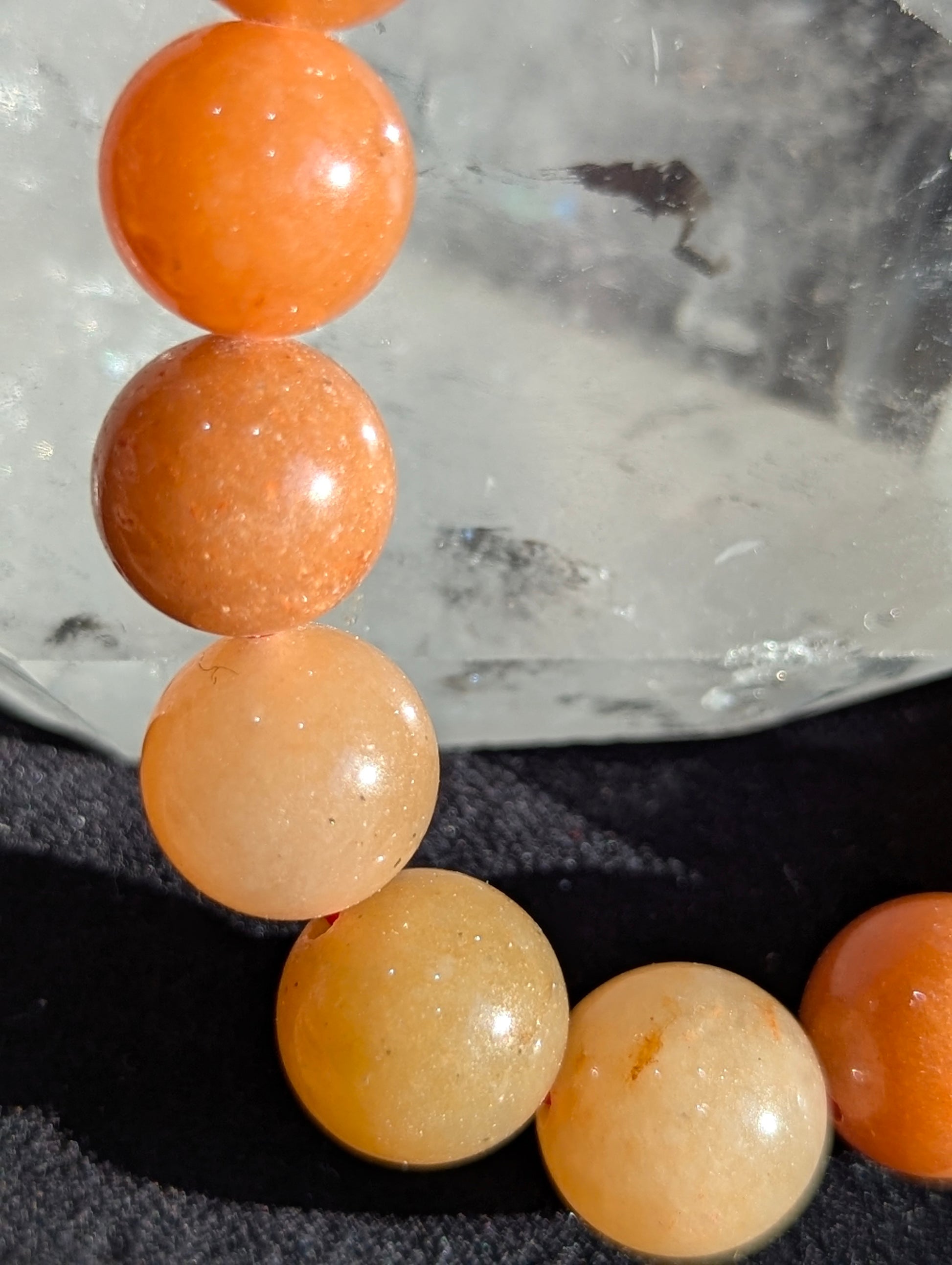 Macro close-up view of polished 10mm Orange Aventurine spheres, highlighting the vitreous surface luster and subtle internal mineral inclusions characteristic of high-grade quartzite.